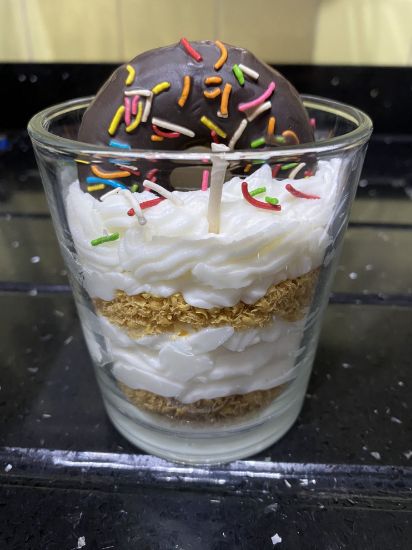 Imagen de Vela aromática decorativa de dona de chocolate con crema pastelera.